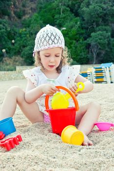 Little girl playing with toys on the beach
