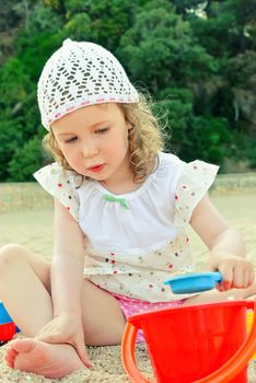 Little girl playing with toys on the beach