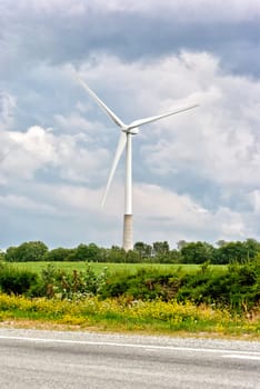 Wind turbine on a cloudy sky background