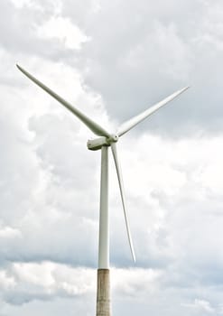 Wind turbine on a cloudy sky background