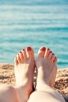 Close up female feet at sandy beach