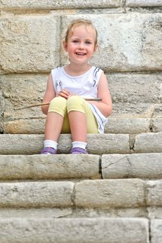 Cute little girl sitting on the stairs