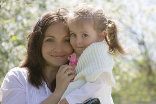 Happy mothre and baby girl in spring garden