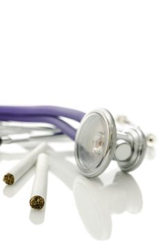 Closeup of two cigarettes and stethoscope isolated over white. Shallow depth of field.