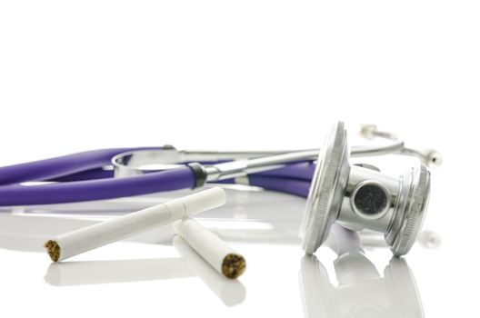 Stethoscope and cigarettes isolated over white background. 