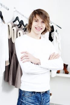 man in shop of clothes, smiles and is happy with purchases