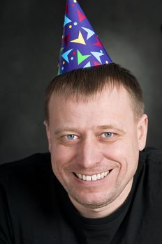 a smiling man in the festive hood on the dark background