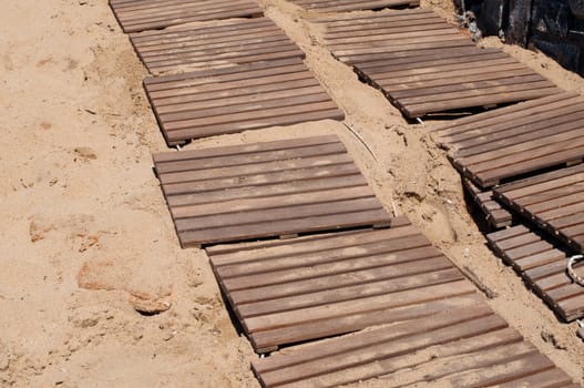 Weathered wooden boardwalk on sand on Crete Island in Greece