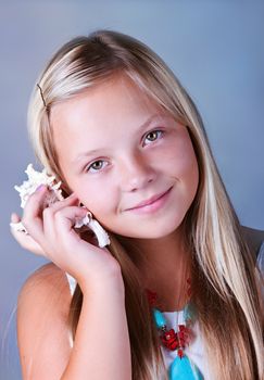 Young girl with shell listening to the sea