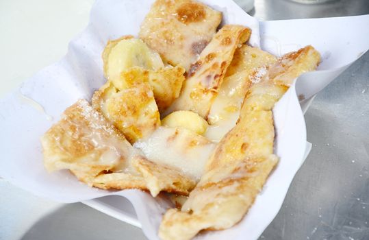 Dessert style of fried Roti with banana cooking on the street in Bangkok, Thailand