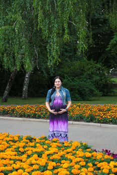 The pregnant girl on walk in city park