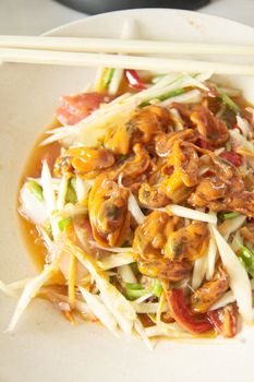 Spicy Green papaya salad (somtam) with cockles, famous Thai food