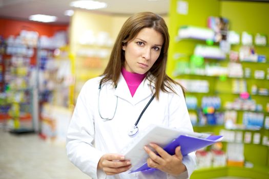 Serious doctor inside pharmacy looking
