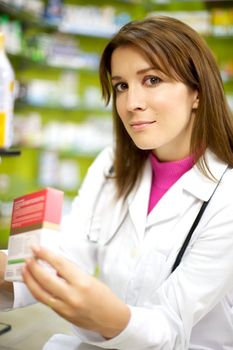 woman doctor working in pharmacy with medicine in her hand