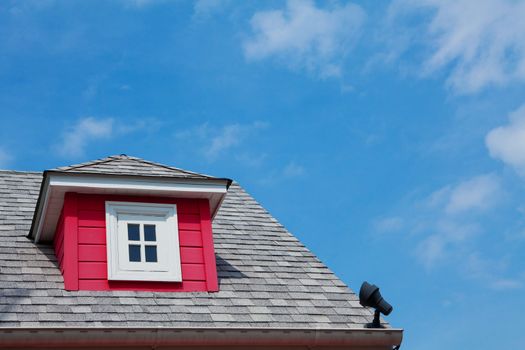 red dormer on the roof of a wood home