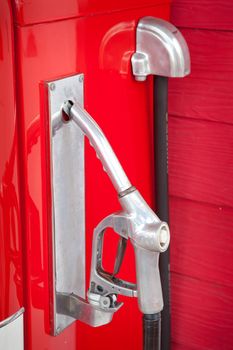vintage gasoline pump against red wood wall