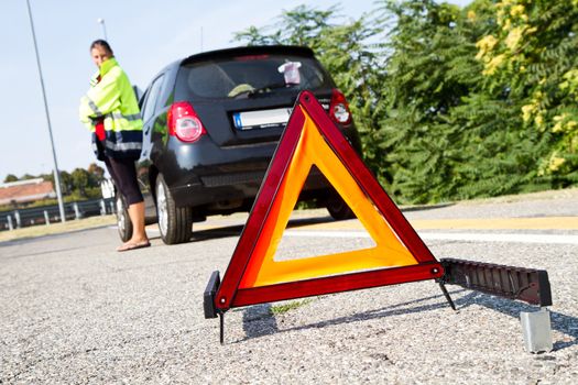 Broken down car with red warning triangle 