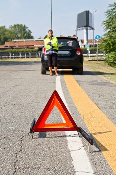 Broken down car with red warning triangle 