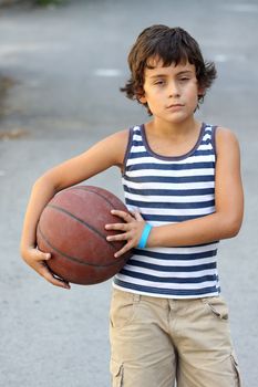 Young cute boy with basketball ball