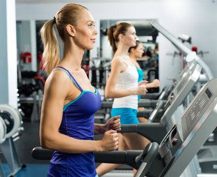 young women running on a treadmill, exercise at the fitness club