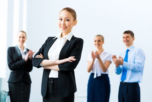 successful business woman in the office, around applauding colleagues