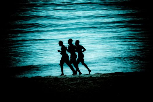 Men running along a beach
