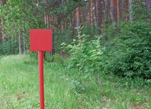 Red metal plate is established on  wood glade