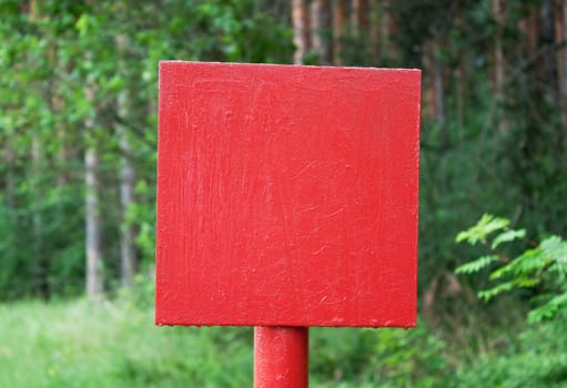 Red metal plate is established on  wood glade