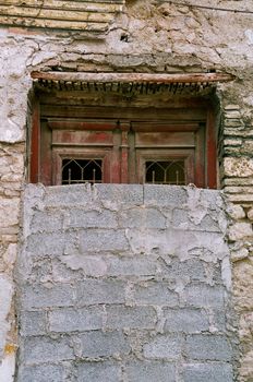 Bricked up vintage door and grungy wall. Abandoned house exterior.