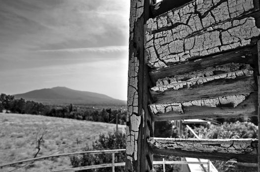 Peeling window shutter and distant city view. Black and white.