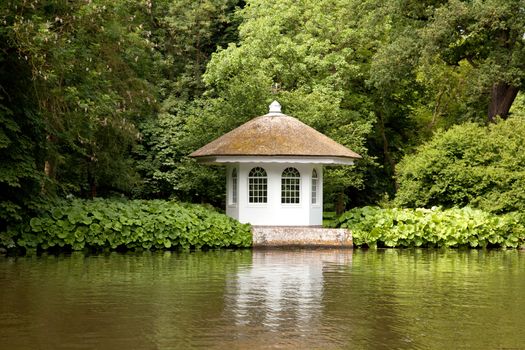 little house in rich garden on the embankment of the river Vecht in Holland