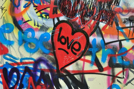 Painted heart on messy smudged wall background. Love graffiti detail.