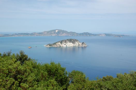 Small island sea and sky horizon landscape. Marathonisi islet, Zakynthos, Greece.