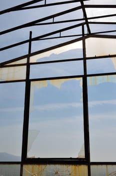 Sunlight reflected on broken glass of vandalized attrium.