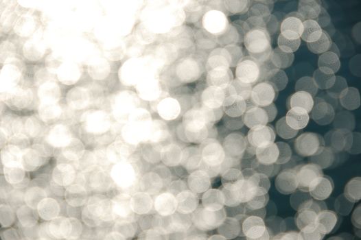 Light shining on sea water. Blurry reflections on sunny day abstract background.