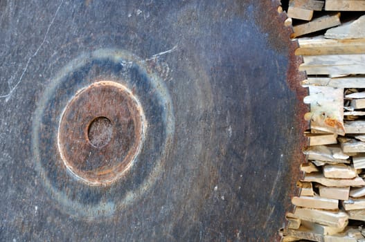 Vintage cutting wheel and pile of marble scrap. Rusty industrial equipment.