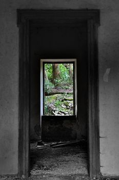 Window view to nature scene in abandoned house interior. Selective saturation.