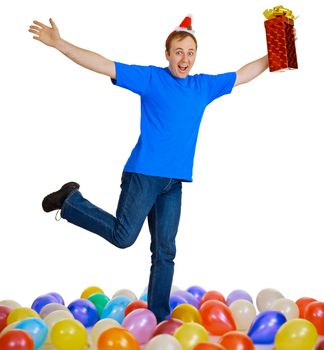A happy man with a Christmas gift dancing among balls