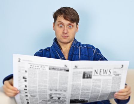 A man reads a newspaper with a amazement