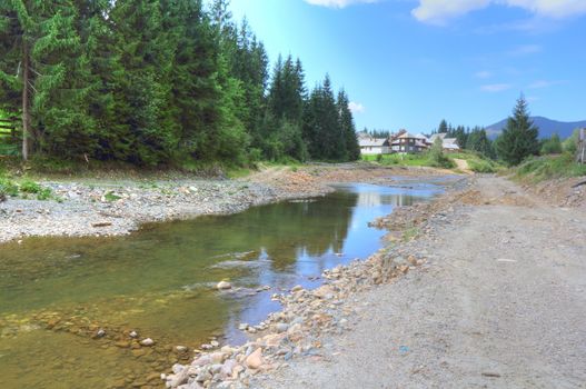 reflections on a slow mountain river with destroyed shores