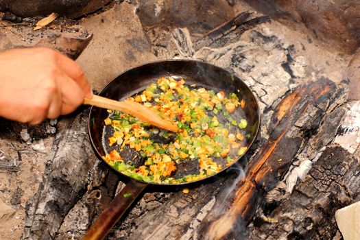 making omelette with mushrooms and onion on campfire