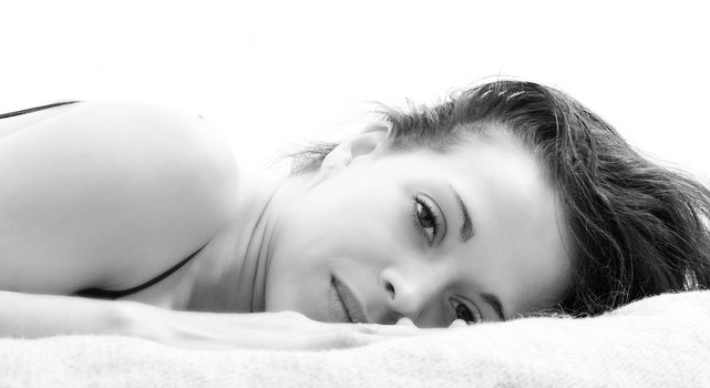 A woman lying on a bed with a rested face 