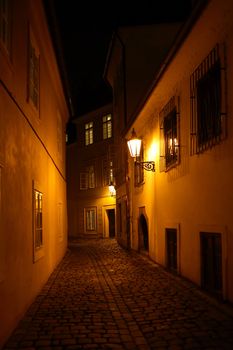 Narrow street in old town with luminous lanterns at night