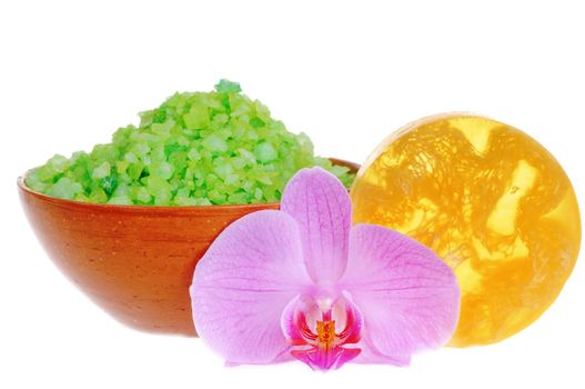 Fresh orchid, natural scrubbing soap and salt for bath isolated on white background. Focus on the flower.