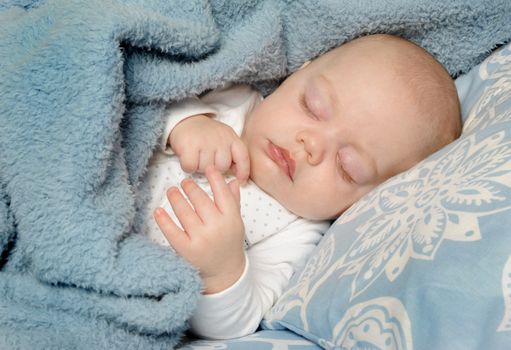 Adorable little baby sleeping peacefully on a blanket