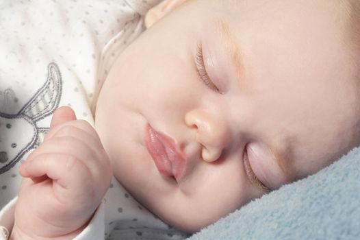 Adorable little baby sleeping peacefully on a blanket