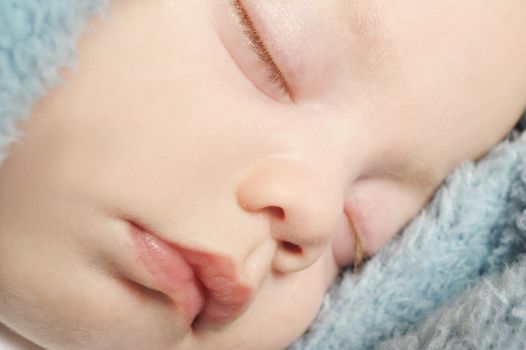 Adorable little baby sleeping peacefully on a blanket