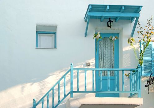 Vintage blue door and window and terrace Decorative with basket flowers on the white wall.