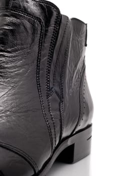 Closeup of Black leather mens boot over white background