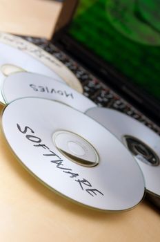 Piracy Concept - Burnt CDs With Illegal Software on Keyboard of Notebook